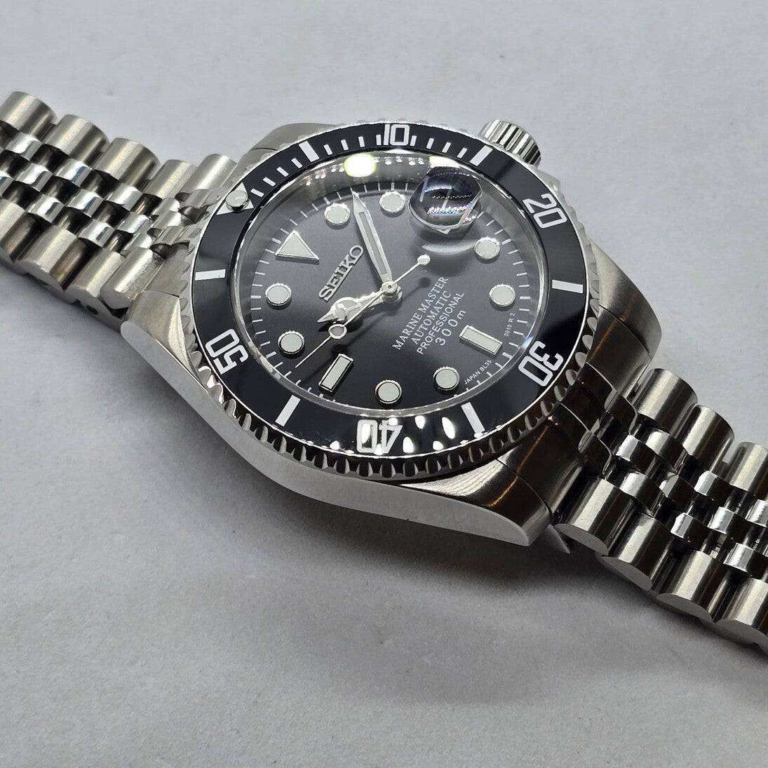 Seiko Mod Submariner Classic Black Draufsicht mit Leuchtindizes und glänzender Keramik-Lünette