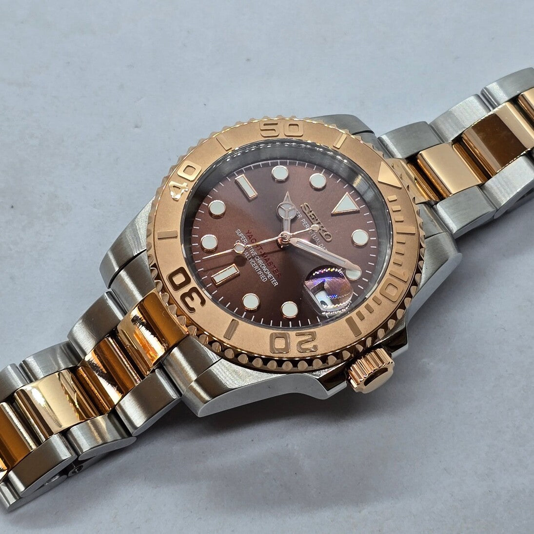 Seiko Mod Yachtmaster Rose Gold Automatikuhr Schrägansicht mit braunem Zifferblatt, Roségold-Lünette und zweifarbigem Edelstahlarmband