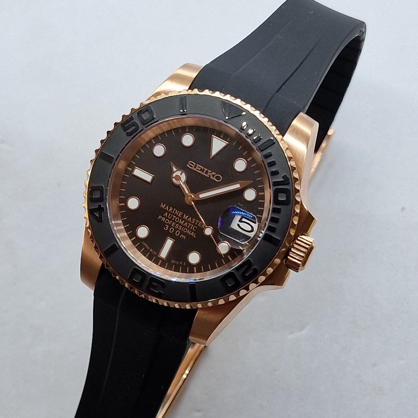 Seiko Mod Yachtmaster Rose Gold Black Schrägansicht mit Roségold-Gehäuse, schwarzer Keramik-Lünette und Kautschukarmband