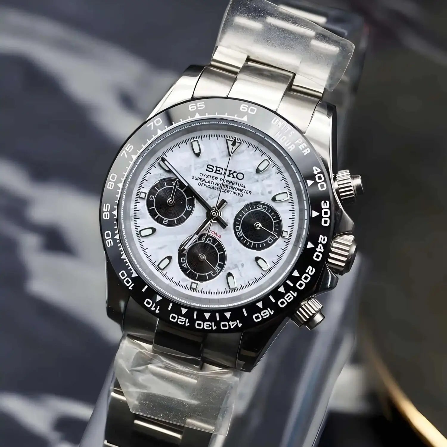 Seiko Mod Daytona Meteorite. Watch viewed from the right side with striking meteorite dial, black bezel, and stainless steel bracelet. An exclusive tribute to the Daytona