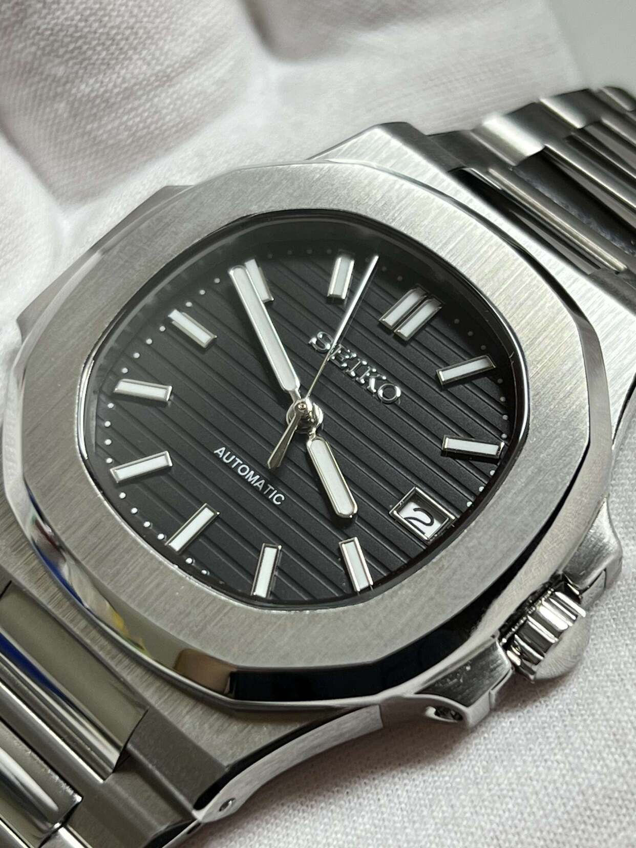 Seiko mod Nautilus black dial macro with vertical pattern and polished hour markers