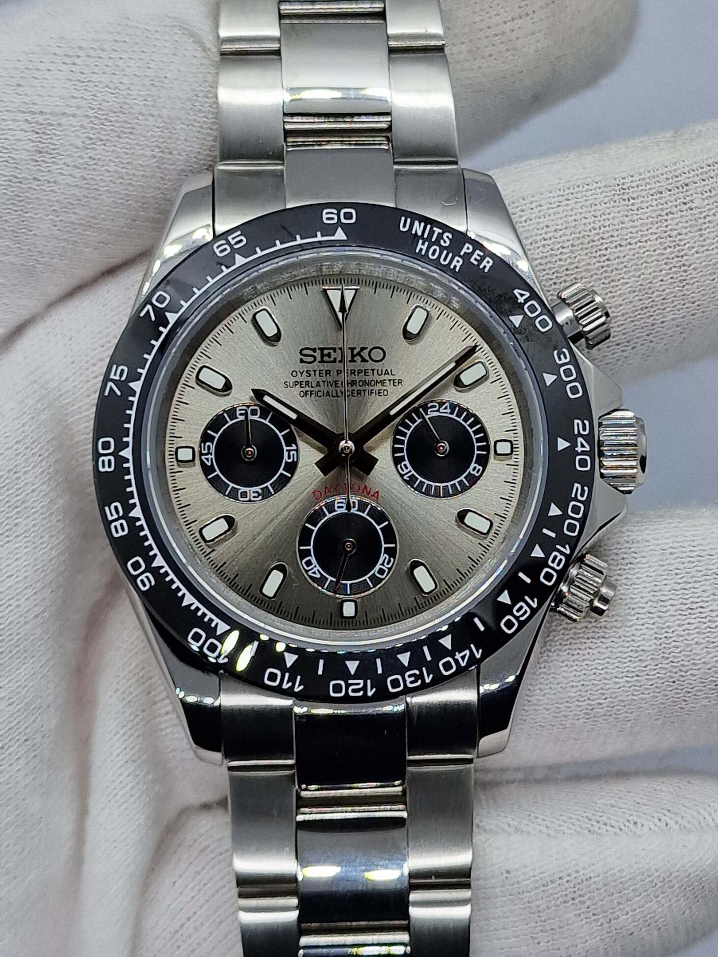 Seiko Mod Daytona Champagne horizontale Ansicht mit champagnerfarbenem Zifferblatt, schwarzer Lünette und Edelstahlarmband