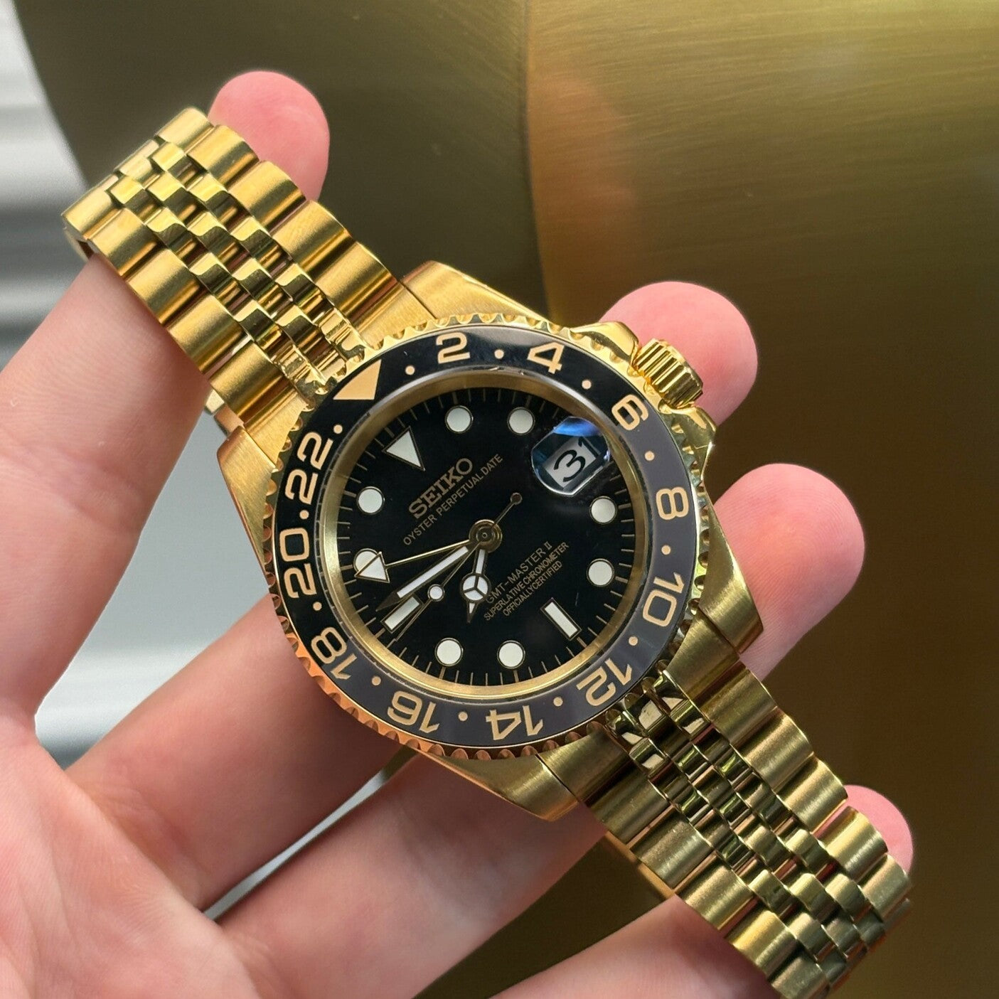 GMT Gold Schrägansicht, polierte goldene Bandanstöße, Jubilee Armband Glieder, Edelstahl Gold Konstruktion, GMT Taucheruhr