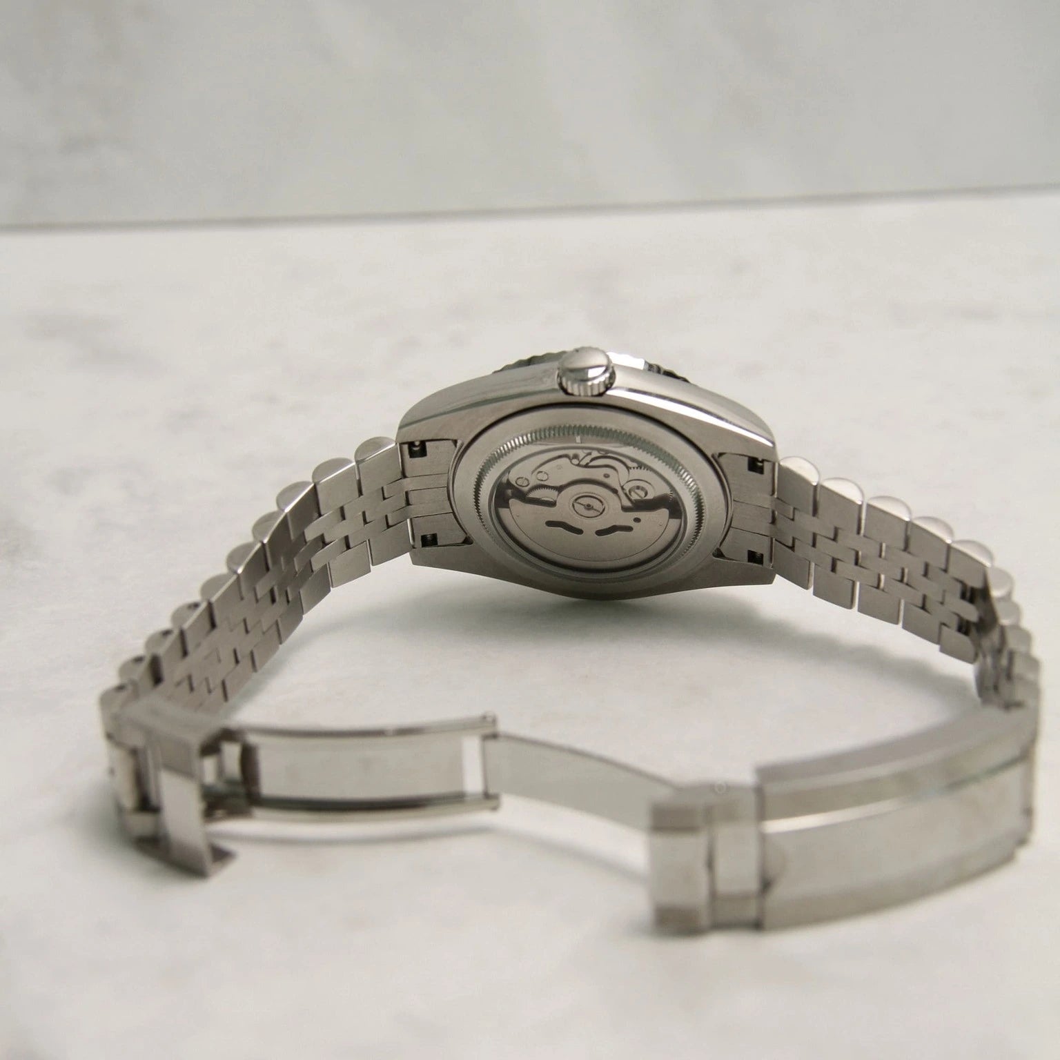 Seiko Mod Datejust Mint Green Arabic mit transparentem Gehäuseboden, sichtbarem NH35 Automatikwerk, Jubilee-Armband auf Marmor-Hintergrund