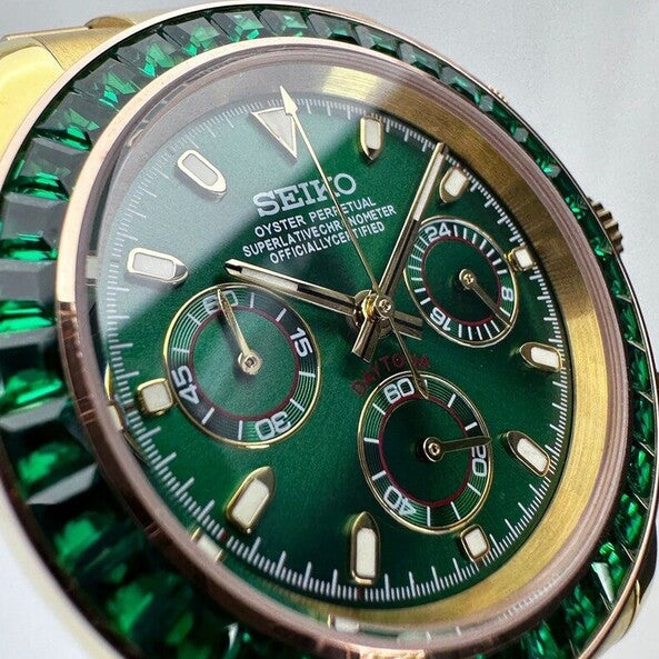Nahaufnahme der Seiko Mod Daytona Green Emerald mit Green Emerald Sonnenschliff-Zifferblatt, vergoldeten Totalisatoren, VK63 Chronograph-Funktion und detaillierter Smaragd-besetzter Lünette
