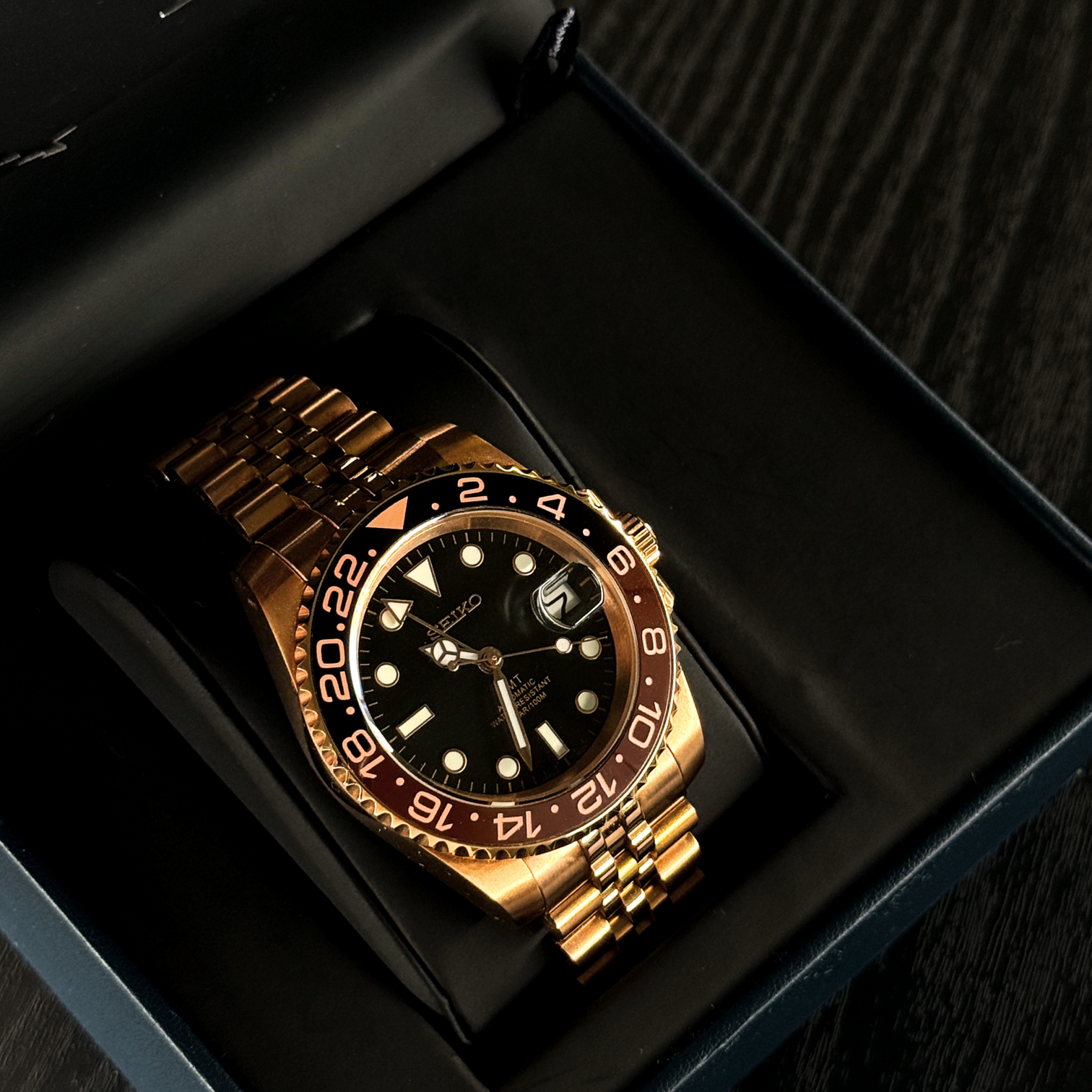 Seiko Mod GMT Rootbeer Rose Gold in Display Box präsentiert vollständiges Jubilee Armband, Rootbeer Zifferblatt Kontrast und luxuriöse Roségold Verarbeitung