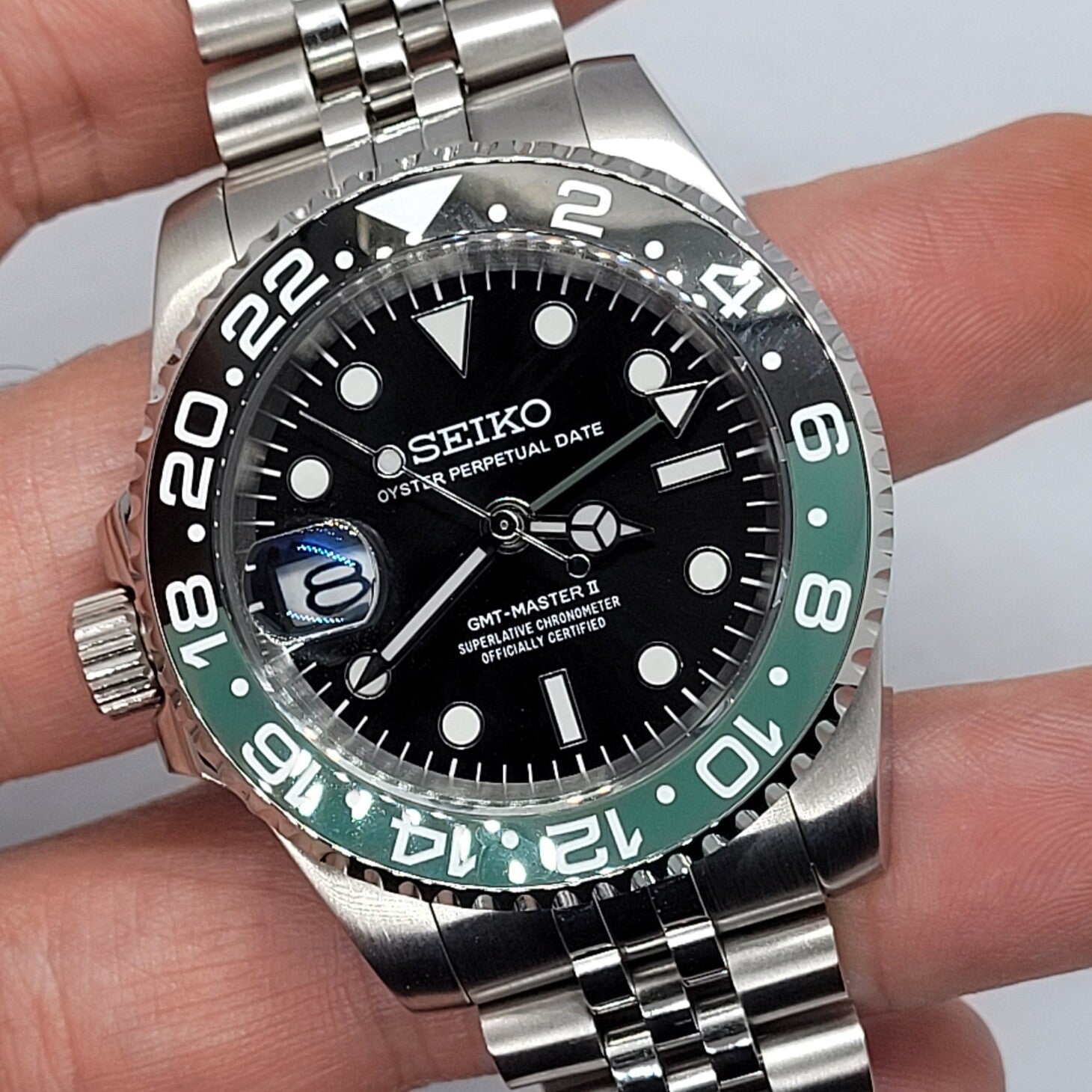 Seiko Mod GMT Sprite Handansicht mit vergrößertem Datumsfenster, detaillierten Stundenindizes und GMT-Zeiger