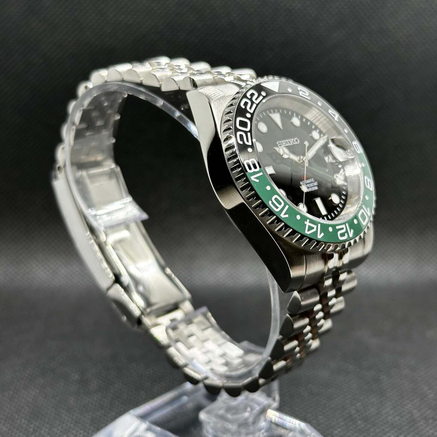 Seiko Mod GMT Sprite Schrägansicht mit NH34 GMT-Uhrwerk, grün-schwarzer Lünette und Jubilee Armband