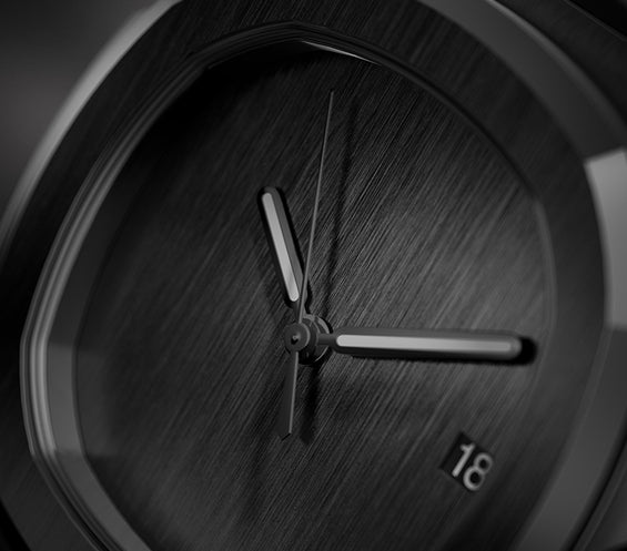 Nahaufnahme des gebürsteten schwarzen Zifferblatts mit minimalistischen Zeigern und Datumsanzeige