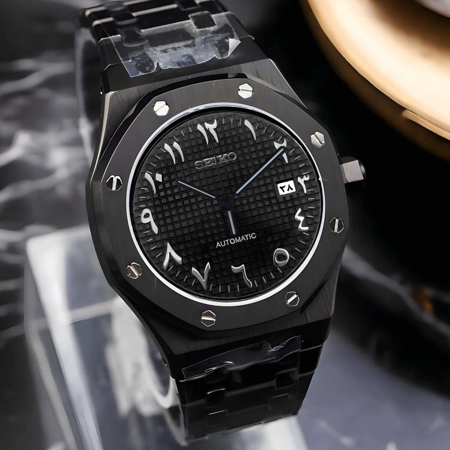 Schrägansicht der Seiko Mod Royal Oak All Black Arabic mit arabischen Ziffern, Waffle-Muster und gebürstetem schwarzem Edelstahlgehäuse