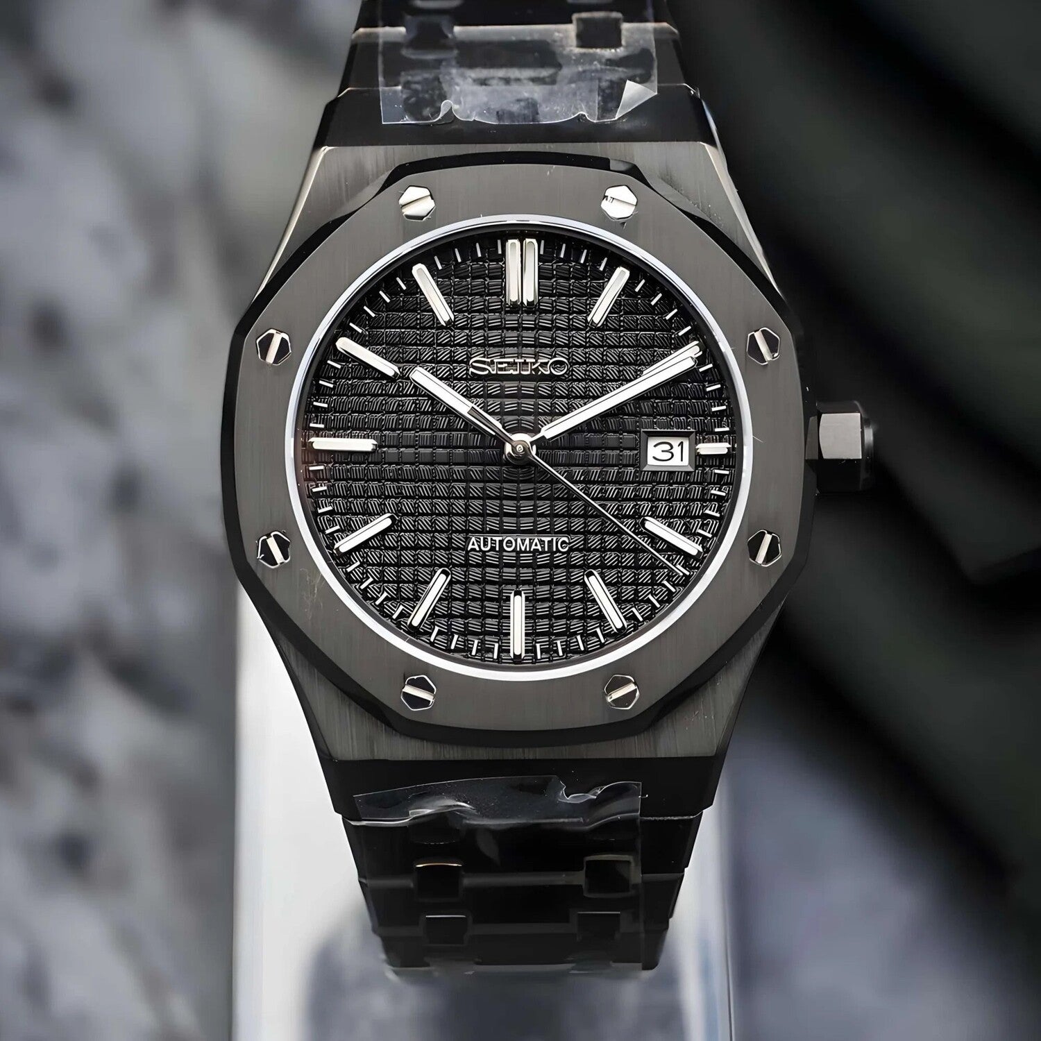 Frontansicht der Seiko Mod Royal Oak All Black mit detailliertem Waffle-Zifferblatt, leuchtenden silbernen Indizes und Saphirglas