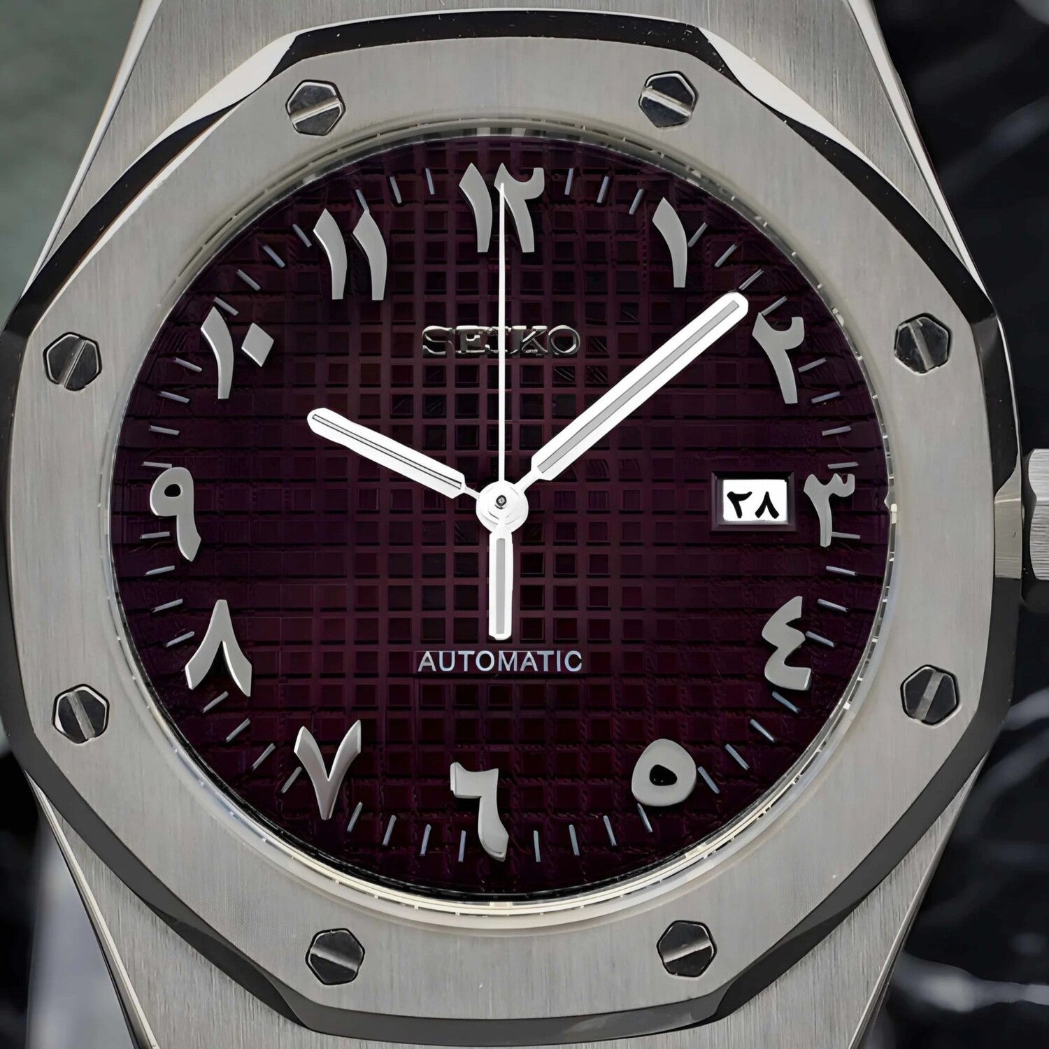 Nahaufnahme des Seiko Mod Royal Oak Brown Arabic Zifferblatts mit arabischen Ziffern, silbernen Zeigern und gebürsteter achteckiger Lünette