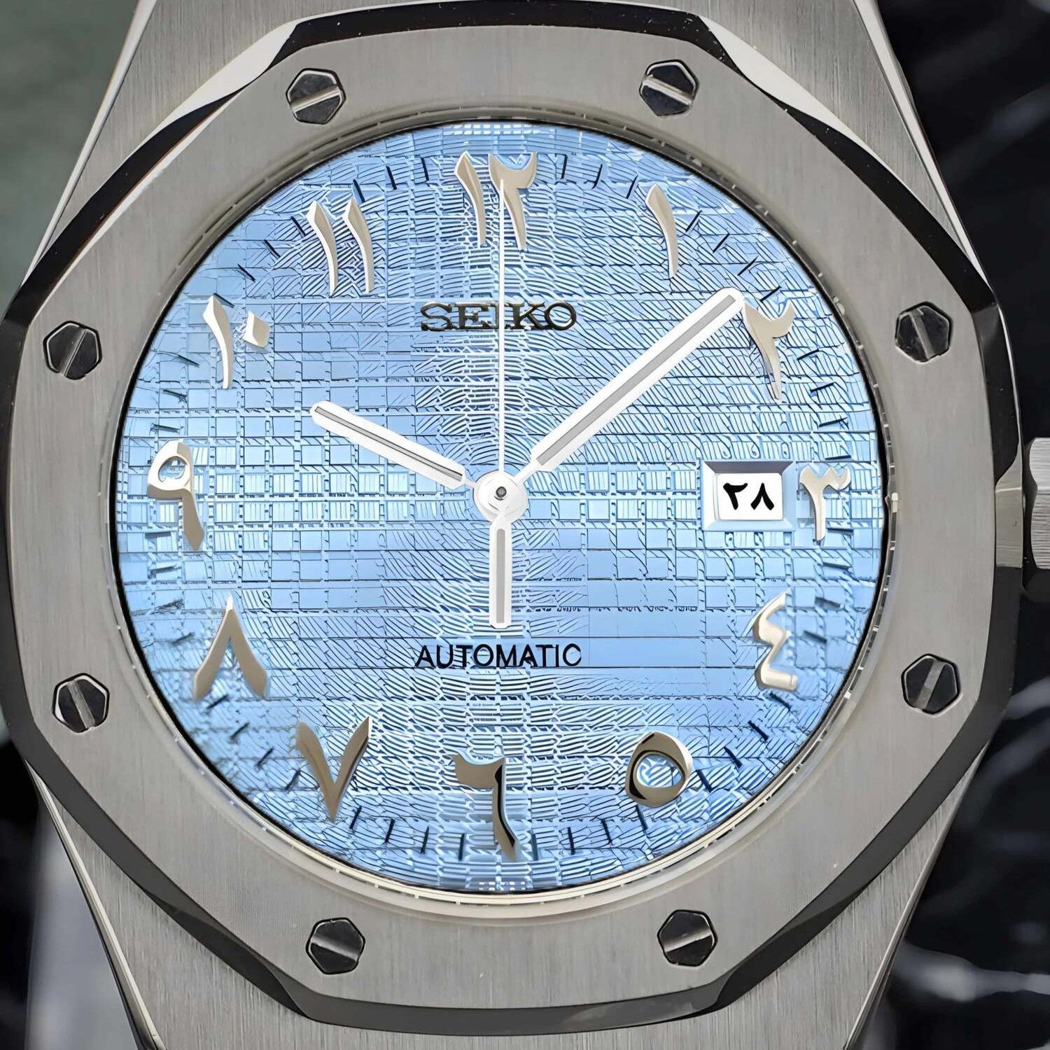 Nahaufnahme des Seiko Mod Royal Oak Ice Blue Arabic Zifferblatts mit eisblauem strukturiertem Muster, arabischen Ziffern und Datumsfenster