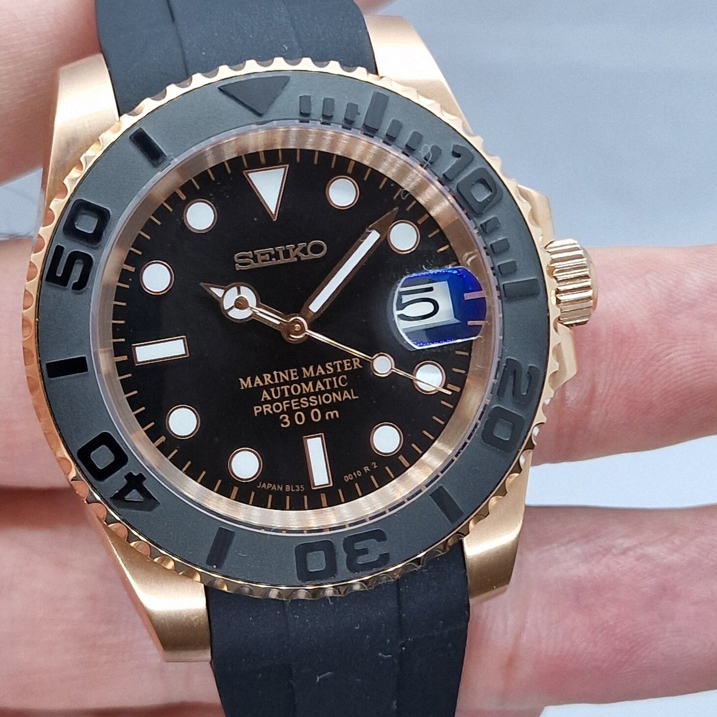 Seiko Mod Yachtmaster Rose Gold Black Zifferblatt Nahaufnahme mit Leuchtindizes und goldenen Akzenten